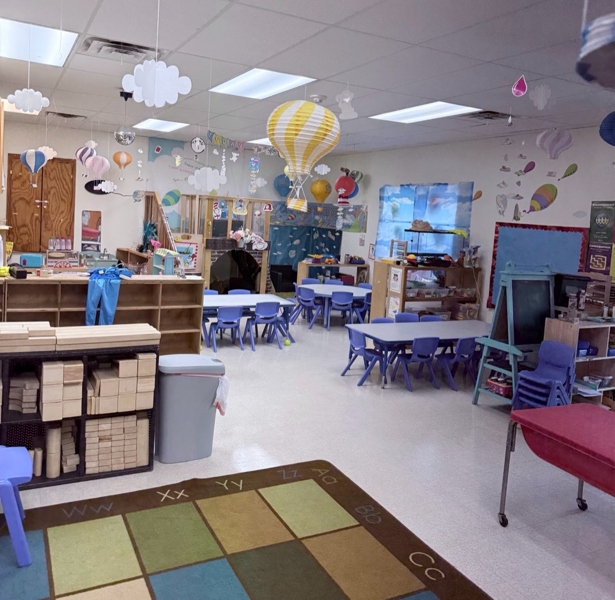 Large classroom with a colorful rug and hot-air-balloon decorations
