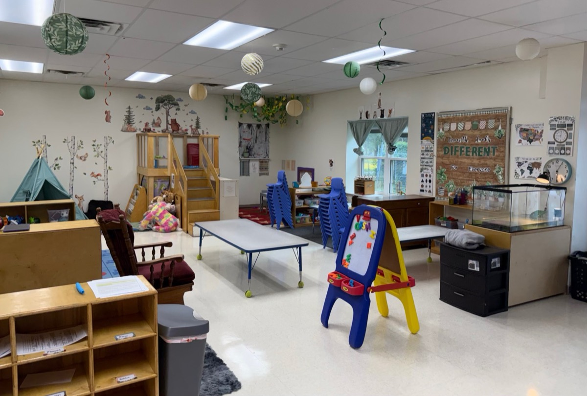 Classroom with an easel, play tent, and learning shelves